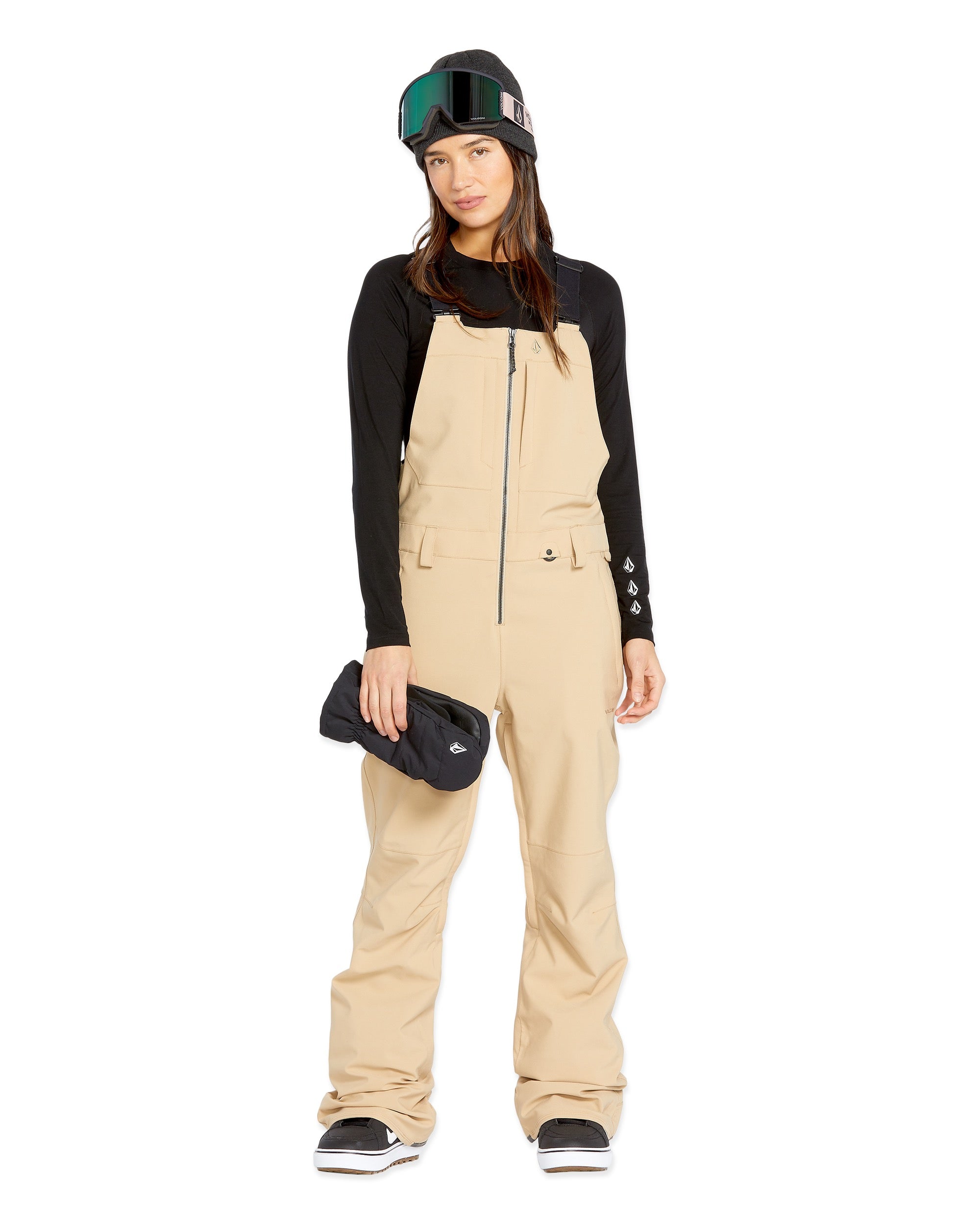 Volcom Women's Swift Bib Overall - A tan bib overall with a black zipper and two front pockets, featuring a small white logo on the right pocket.