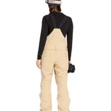Volcom Women's Swift Bib Overall - Beige bib overalls with a black strap and buckle on the back, featuring two front pockets.