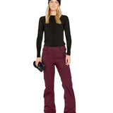 Volcom Women's Genus Stretch Pant 2025 - A pair of maroon snow pants with a zippered pocket on the side and a button fly.