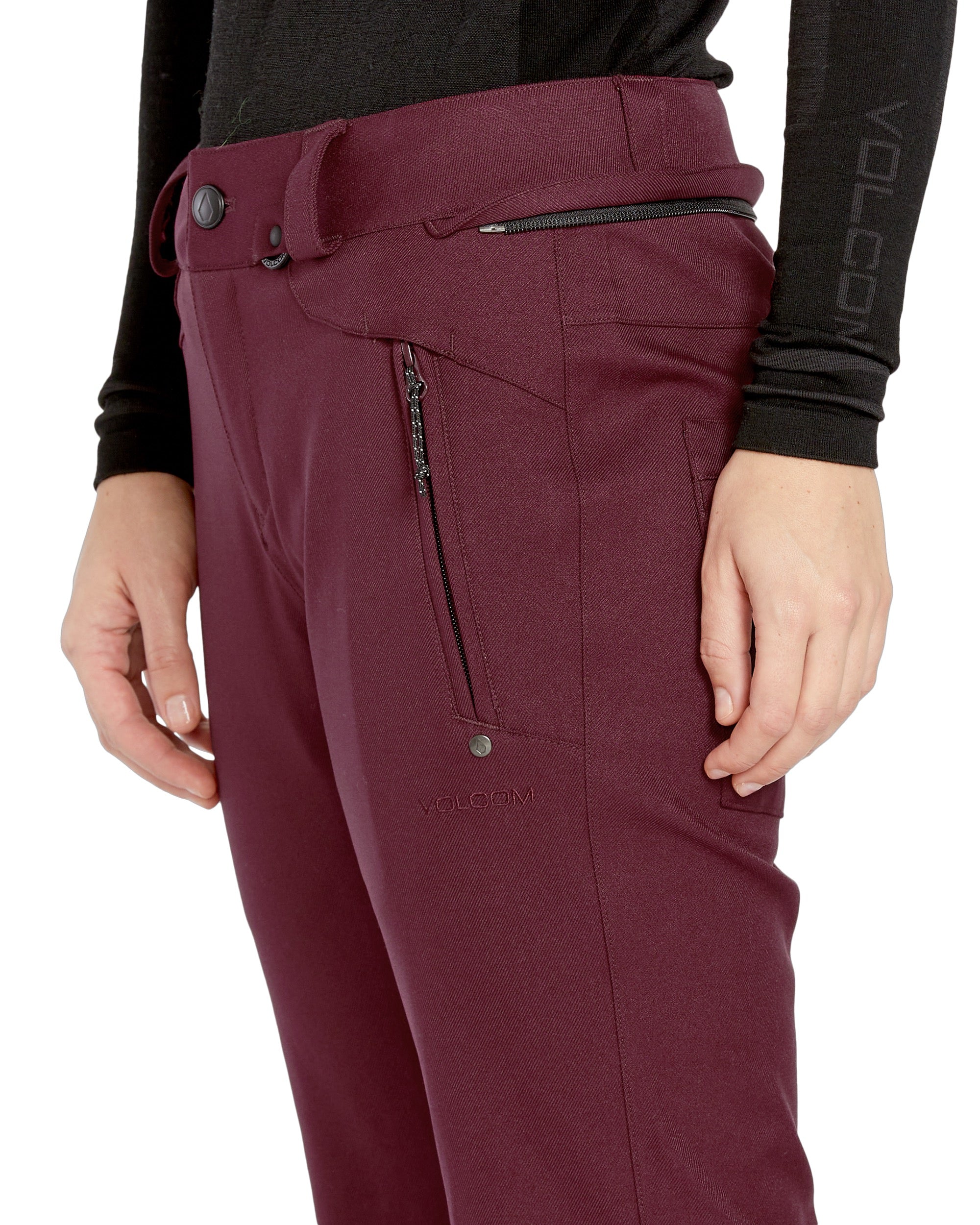 Volcom Women's Genus Stretch Pant 2025 - A pair of maroon snow pants with a zippered pocket on the side and a black zipper pull.
