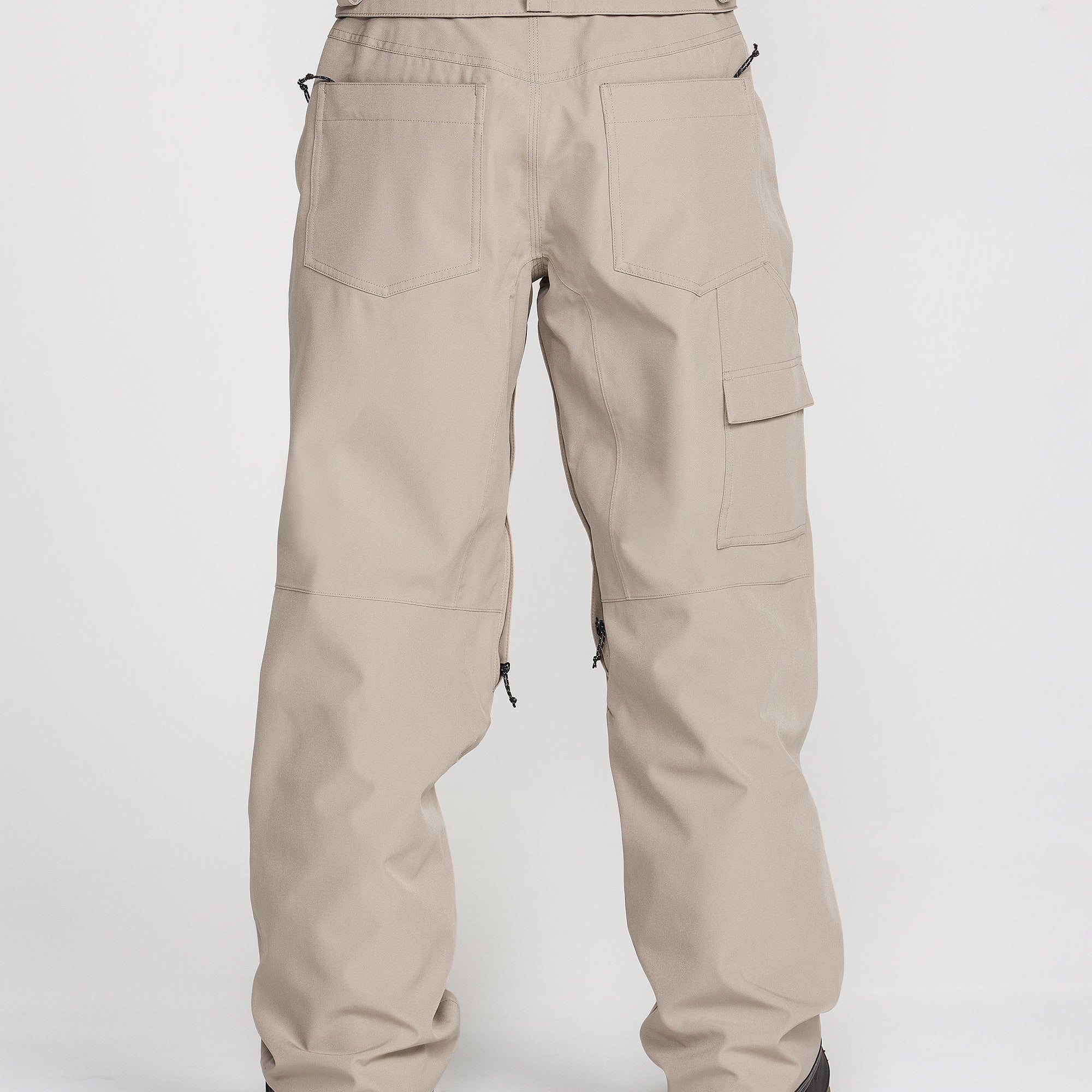Women’s baggy snow pants in light khaki with cargo pocket panels and relaxed leg.