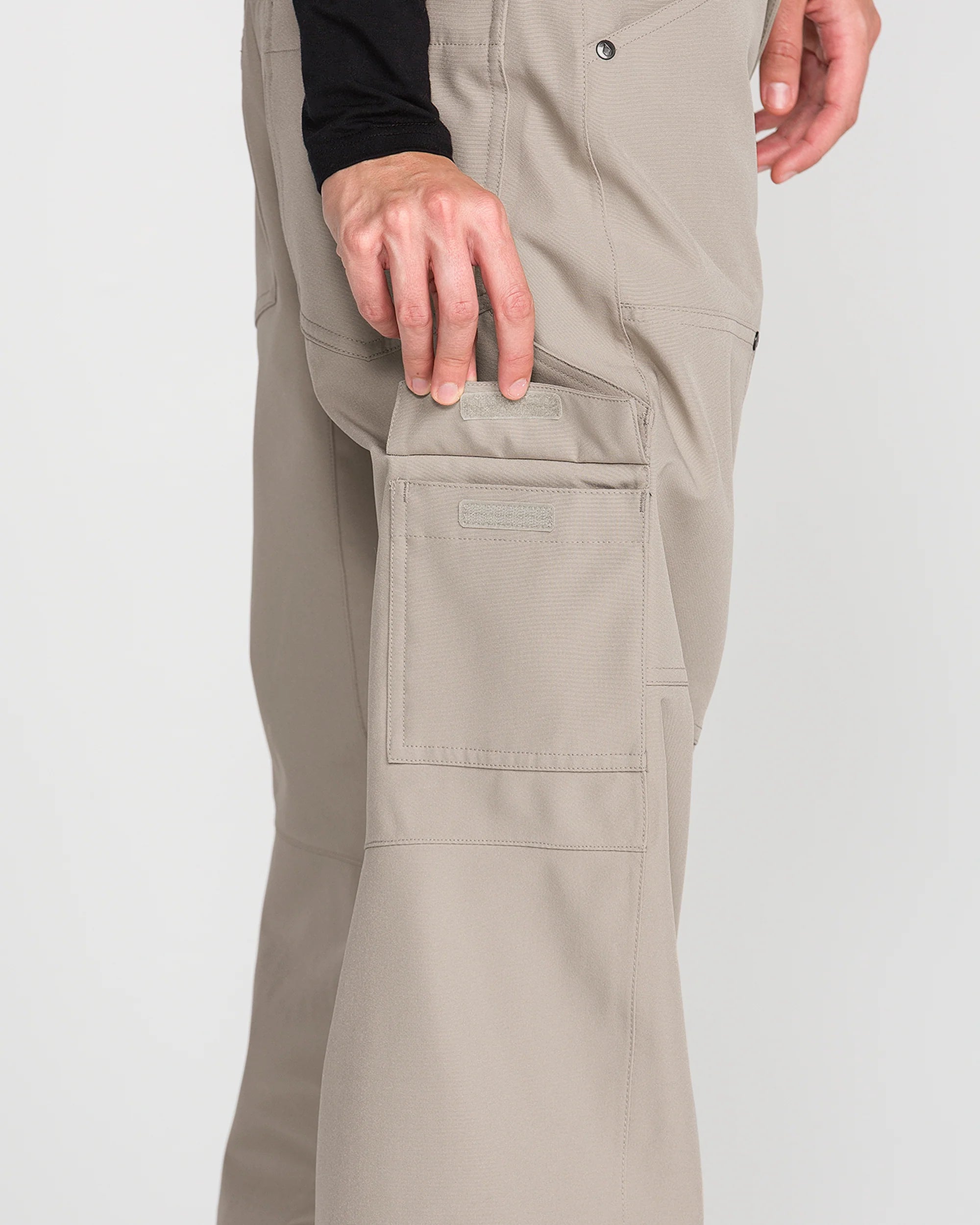 Light khaki baggy snow pants with large front cargo pocket and stitched seams.