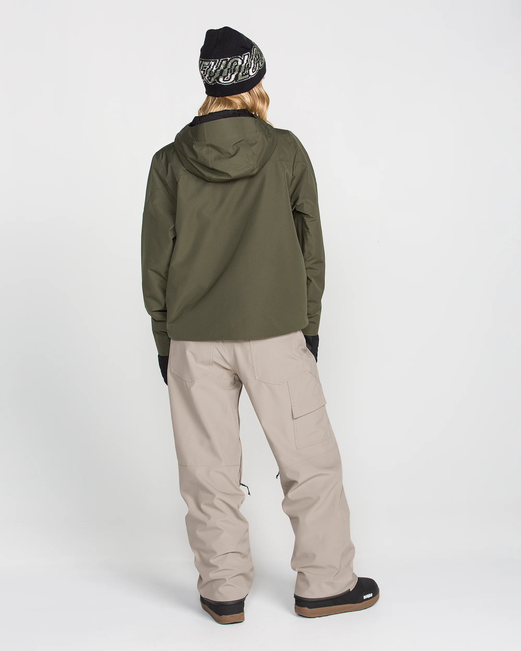 Women’s baggy snow pants in light khaki, worn with cuffed leg and cargo pocket panels.