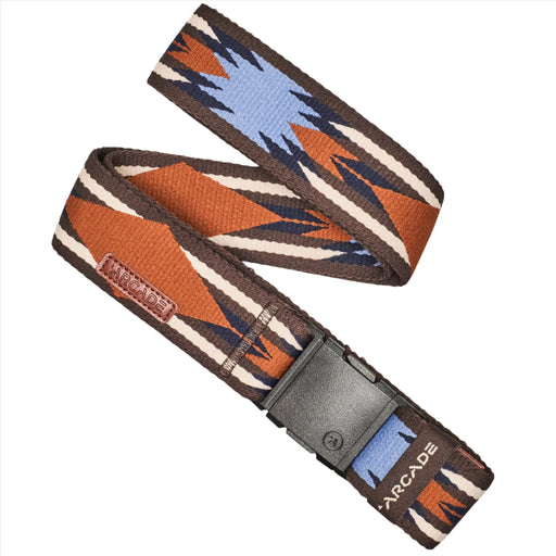 A belt with a geometric pattern in brown, blue, and white. The belt features zigzag and diamond shapes, with a plastic buckle. There is a small rectangular tag with 'Arcade' written on it.