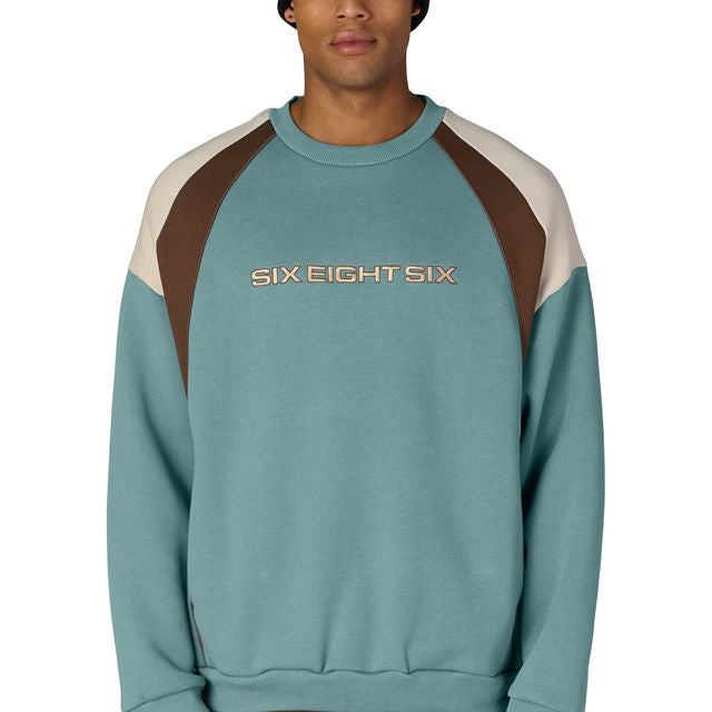 Colorblocked crewneck sweatshirt in teal with brown shoulder panels and ribbed cuffs