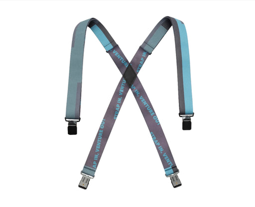 A pair of suspenders featuring a crisscross pattern in shades of blue and grey. The suspenders have the text 'STRAP IN. VENTURE OUT.' printed in blue on the grey section and black clasps at the ends.