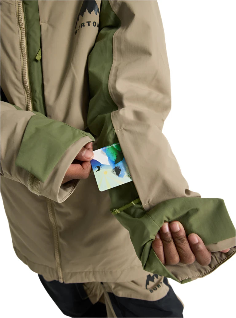 Burton Junior's Hillslope Insulated Jacket 2025 - A tan jacket with a green zipper and logo on the chest, worn by a model in front of a white background.