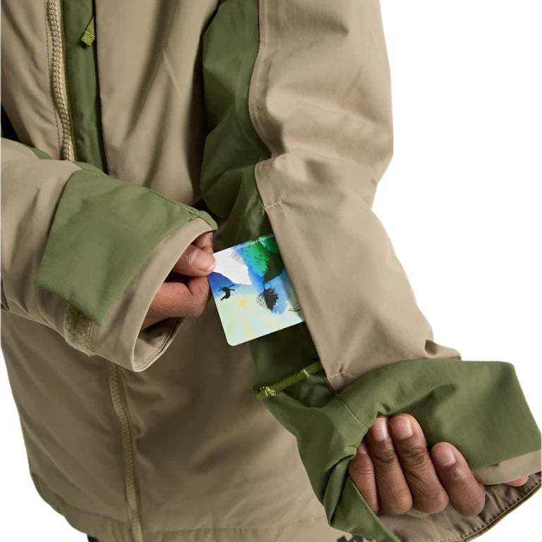 Burton Junior's Hillslope Insulated Jacket 2025 - A tan jacket with a green zipper and logo on the chest, worn by a model in front of a white background.