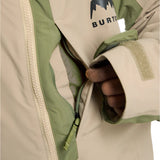 Burton Junior's Hillslope Insulated Jacket 2025 - A cream-colored jacket with a green stripe on the sleeve and a black logo featuring a mountain peak above the word "BURTON".