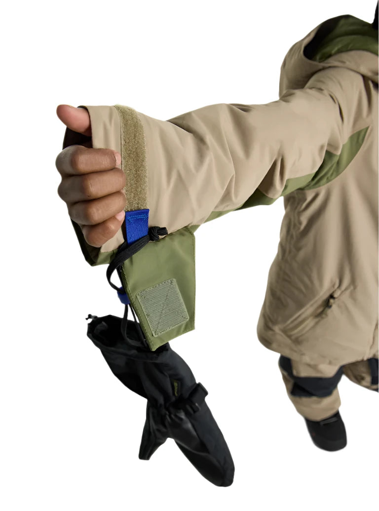 Burton Junior's Hillslope Insulated Jacket - A tan jacket with a green stripe on the sleeve cuff and a blue tag sewn onto it.
