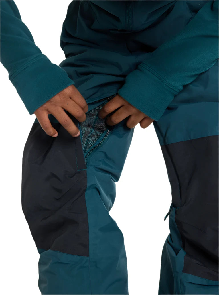 Burton Junior's Skylar 2L Bib Pant 2025 - A pair of dark blue snow pants with a black stripe down the side and adjustable Velcro straps at the waist.