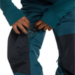 Burton Junior's Skylar 2L Bib Pant 2025 - A pair of dark blue snow pants with a black stripe down the side and adjustable Velcro straps at the waist.