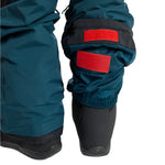 Burton Junior's Skylar 2L Bib Pant 2025 - A pair of dark green snow pants with a black waistband and belt loops, featuring two red patches on the left leg.