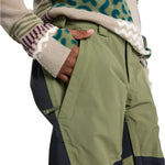 Burton Junior's Skylar 2L Pant 2025 - A pair of olive green snow pants with a black stripe on the side.
