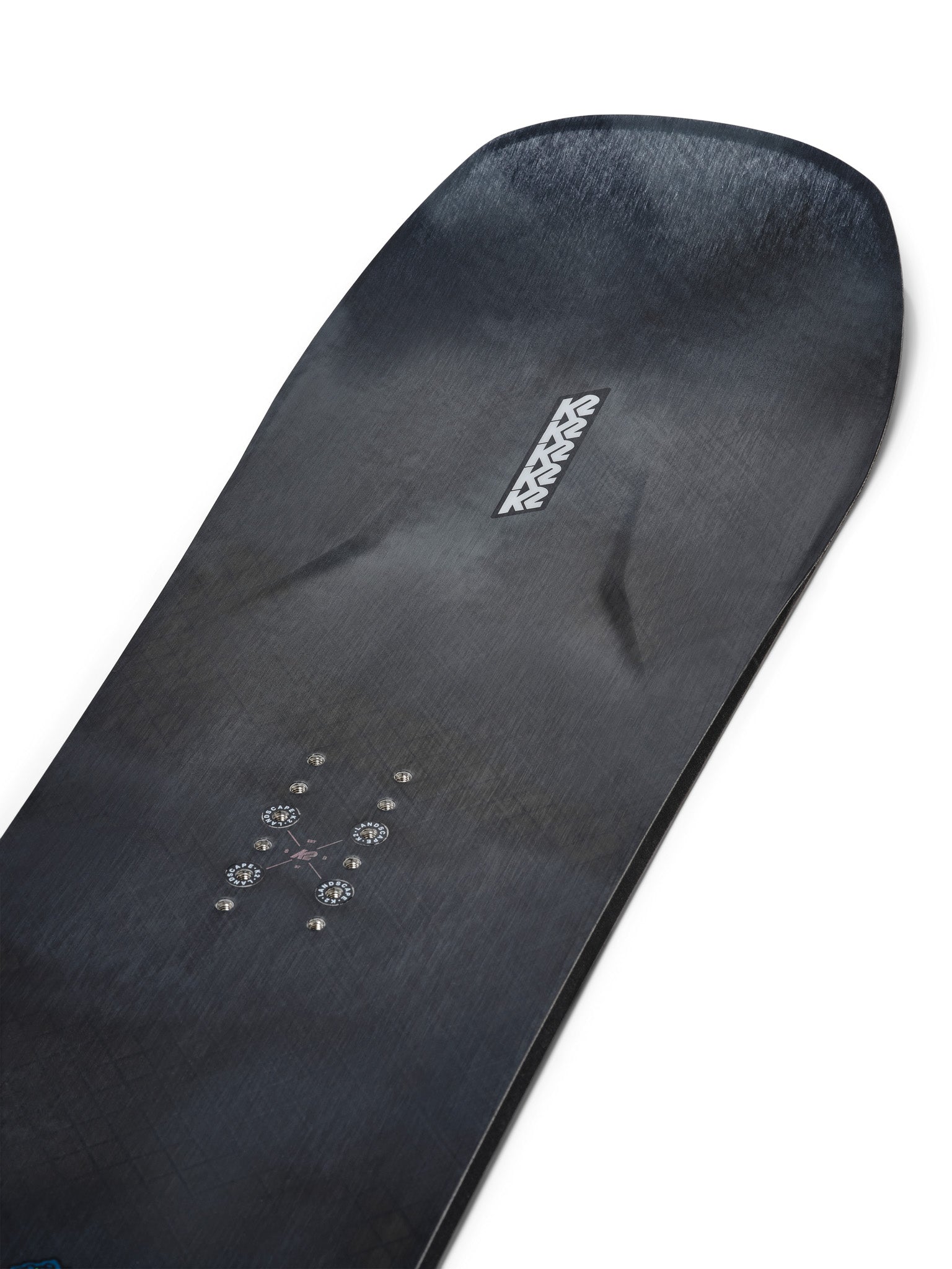 K2 Alchemist snowboard 2025 features a black base with white and blue graphics.