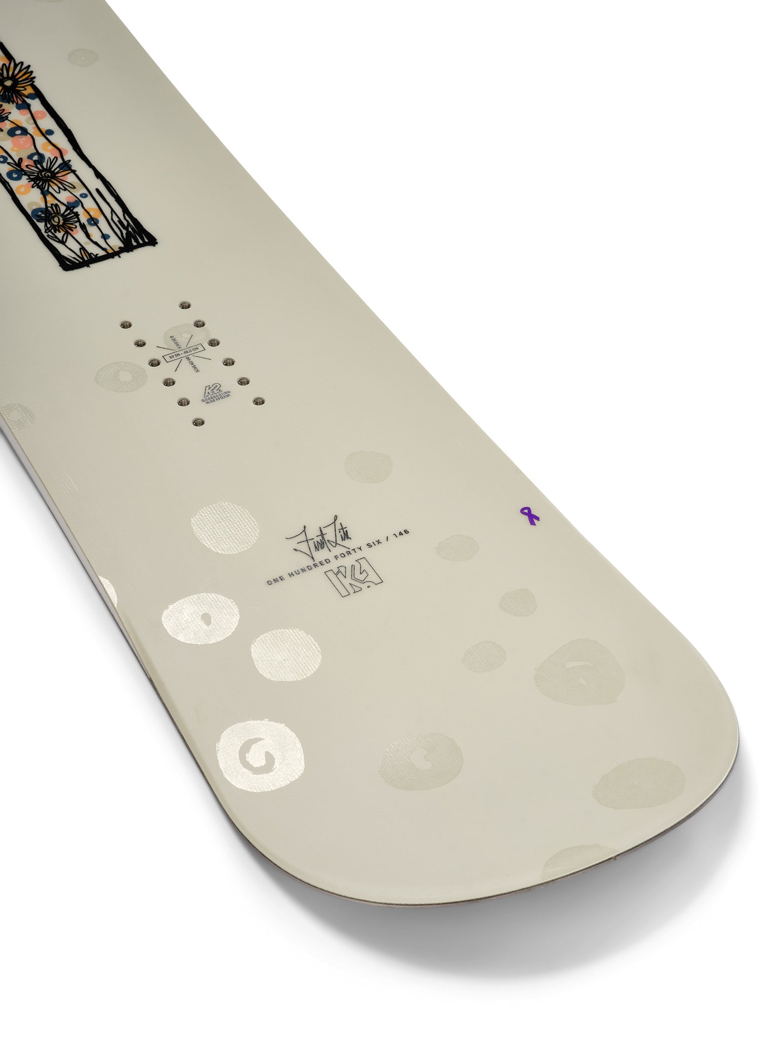 K2 Women's First Lite snowboard 2025 features a white base with purple and floral graphics.