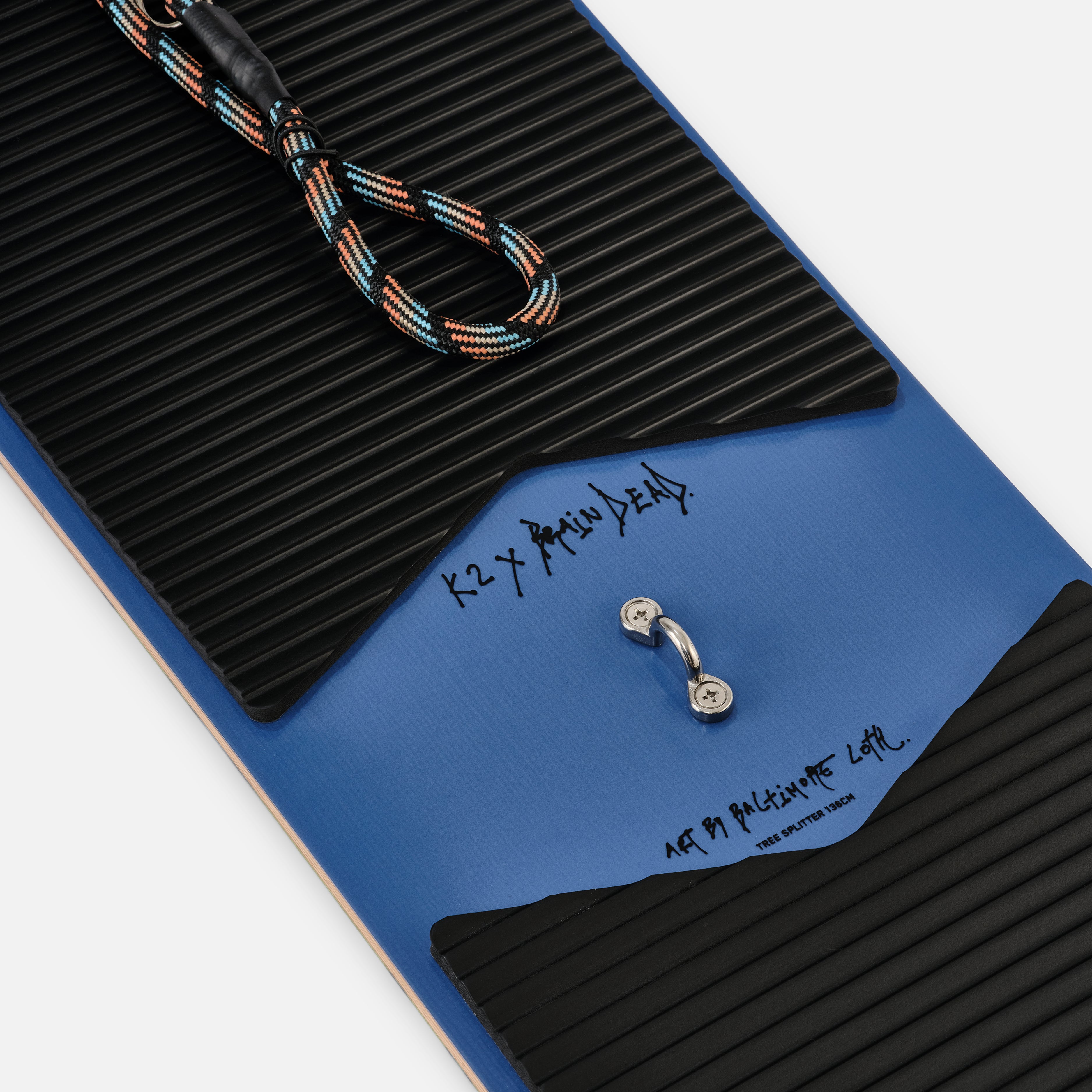 LIMITED EDITION: K2 x Brain Dead Tree Splitter Snowboard 2025 - A blue snowboard with a black textured pattern on top and a black strap at the tip.