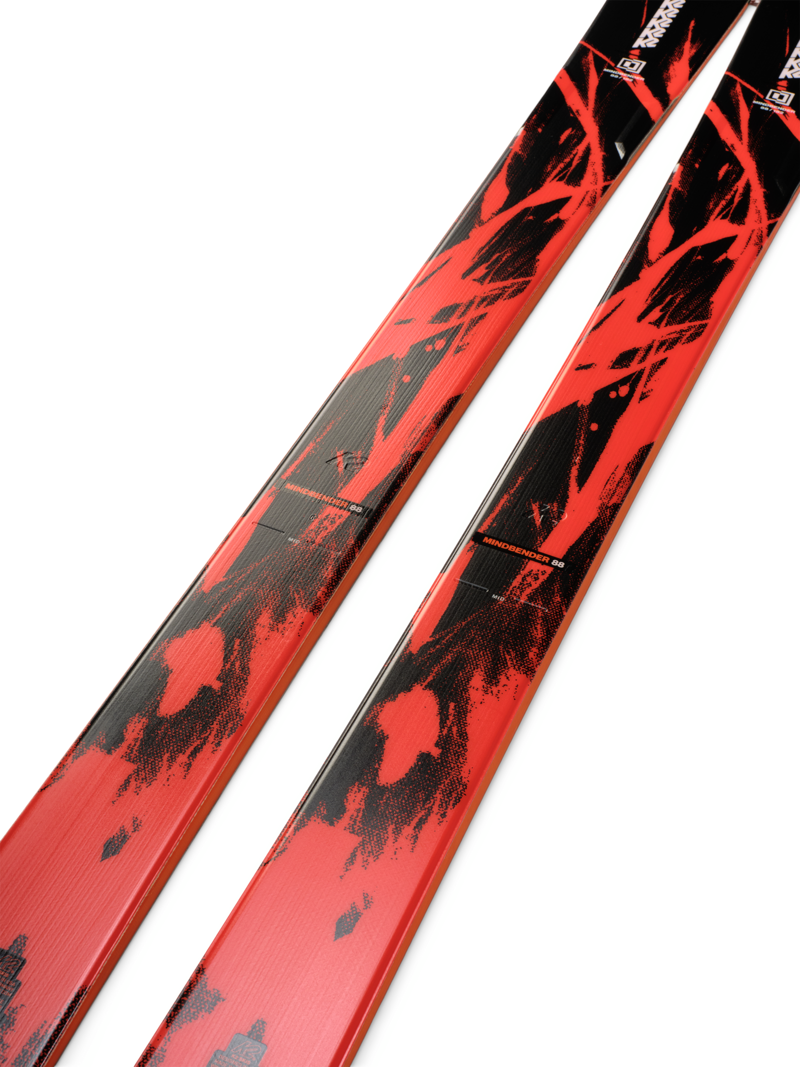 K2 Mindbender 88 skis, angled view of red top with black speckle graphics