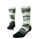 Stance Junior's Hassagore Snow Sock 2025 - A pair of snow socks with a green and grey camouflage pattern, featuring yellow stripes on top.