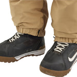 Airblaster Kook Shell Suit 2025 - Black snowboard pants with a white logo on the left thigh and black straps at the ankles.