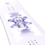 Salomon Women's Lotus Snowboard 2025 - A white snowboard with a purple logo and text on top, featuring a woman riding it in the background.