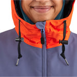 Airblaster Women's Trenchover Insulated Jacket 2025 - A woman wearing a purple jacket with an orange hood and zipper.