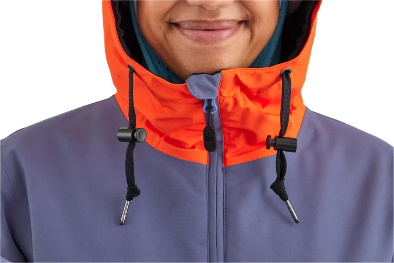 Airblaster Women's Trenchover Insulated Jacket 2025 - A woman wearing a purple jacket with an orange hood and zipper.