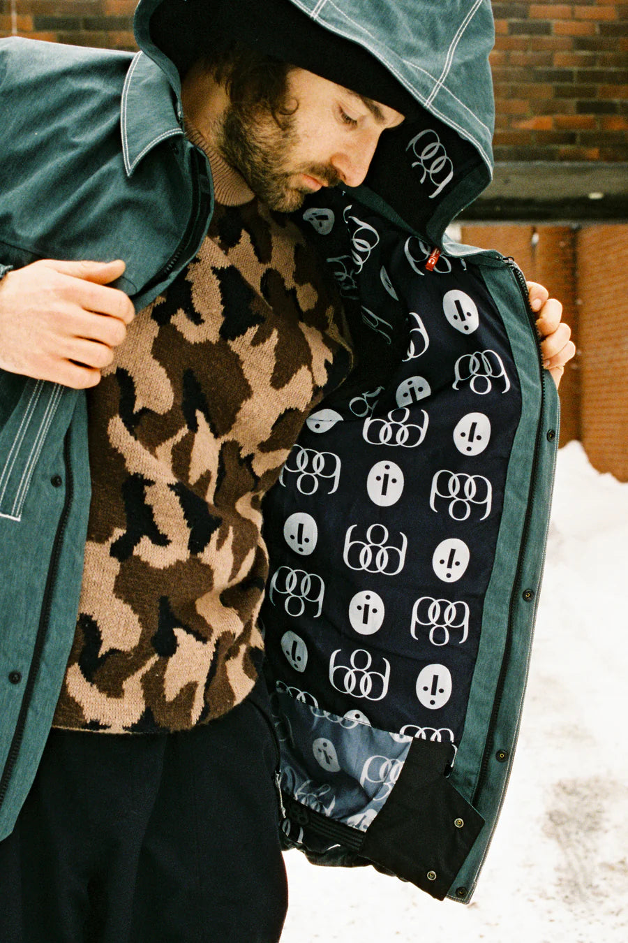 The 686 Dojo Shell Jacket in dark green has an insulated hood and a zippered front.