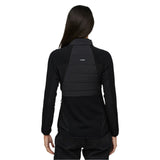 Le Bent Women's Genepi Wool Insulated Hybrid Jacket 2025 - A black jacket with a high collar and zippered pockets, featuring a quilted wool insulation panel on the back.
