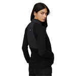 Le Bent Women's Genepi Wool Insulated Hybrid Jacket 2025 - A black jacket with a high collar and zippered pockets, featuring a wool insulation pattern on the back.