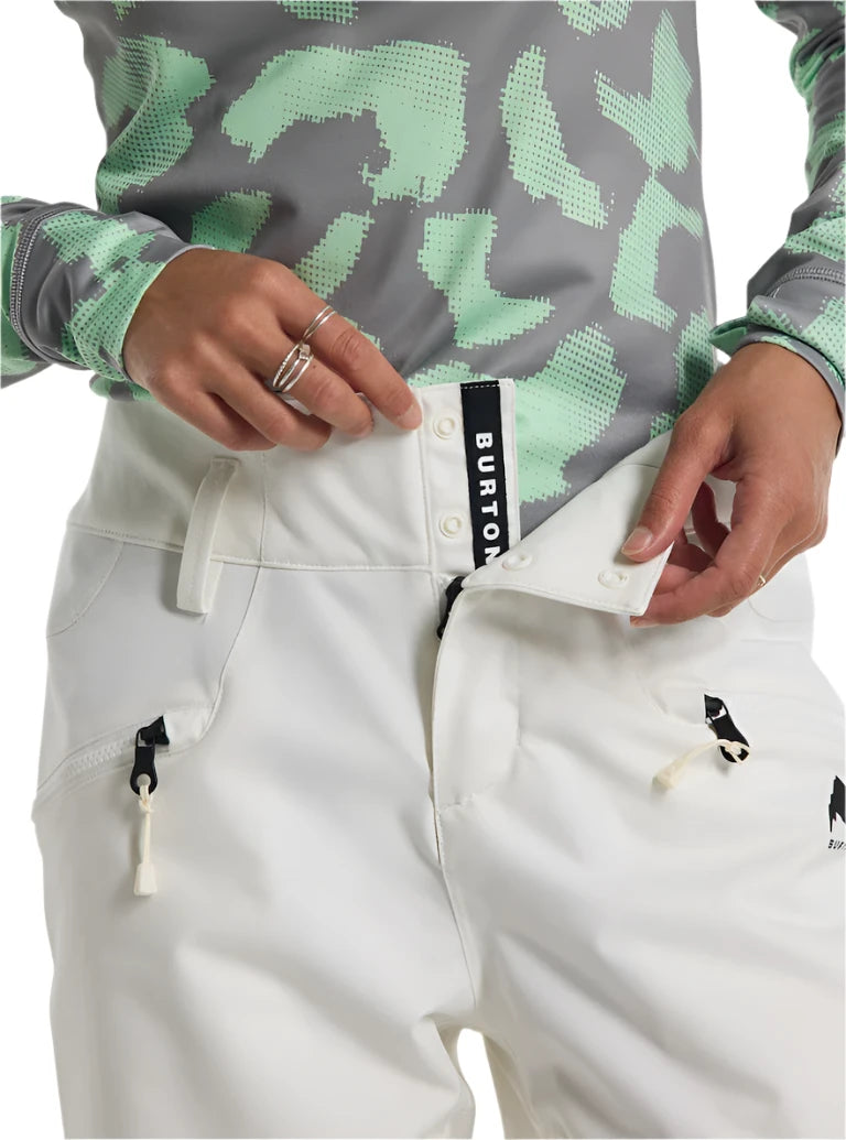 Burton Women's Marcy 2L High Rise Stretch Pants 2025 - A pair of white snow pants with a black stripe down the side and zippered pockets.