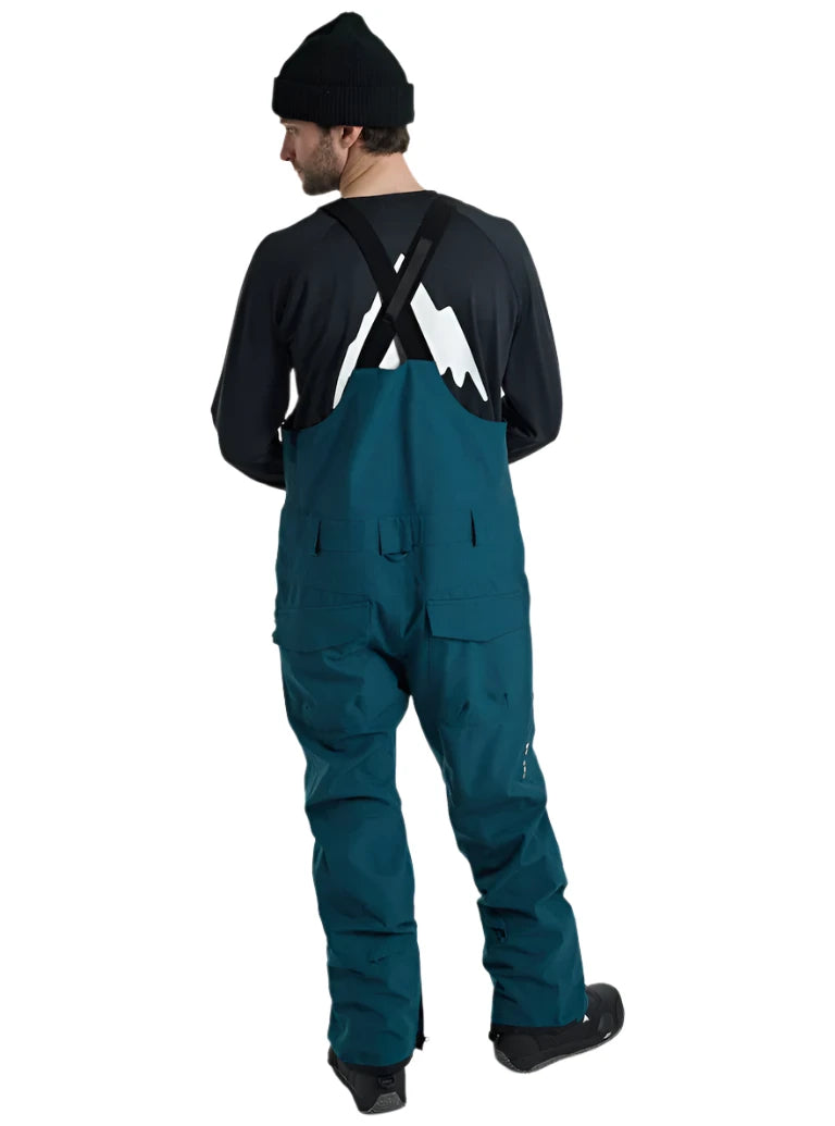 Burton Reserve Bib Pant 2025 - Dark-colored bib pants with a white logo on the left leg and black straps over the shoulders.
