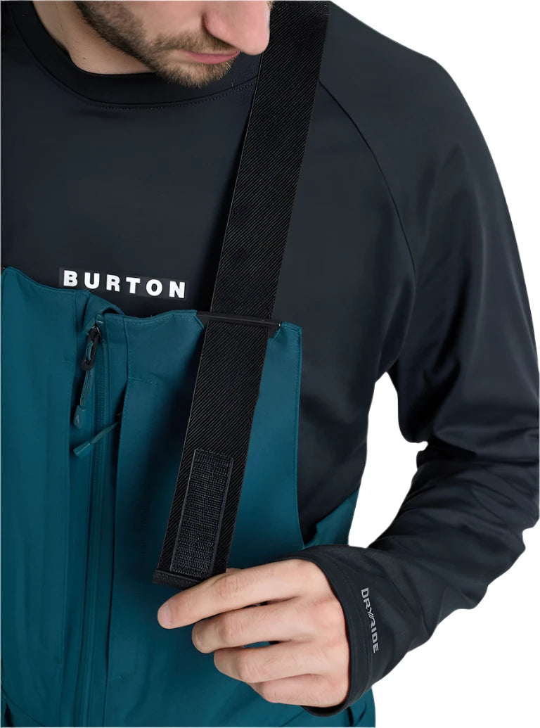 Burton Reserve Bib Pant 2025 - A pair of dark blue snow pants with a zippered pocket on the thigh and adjustable straps at the waist.