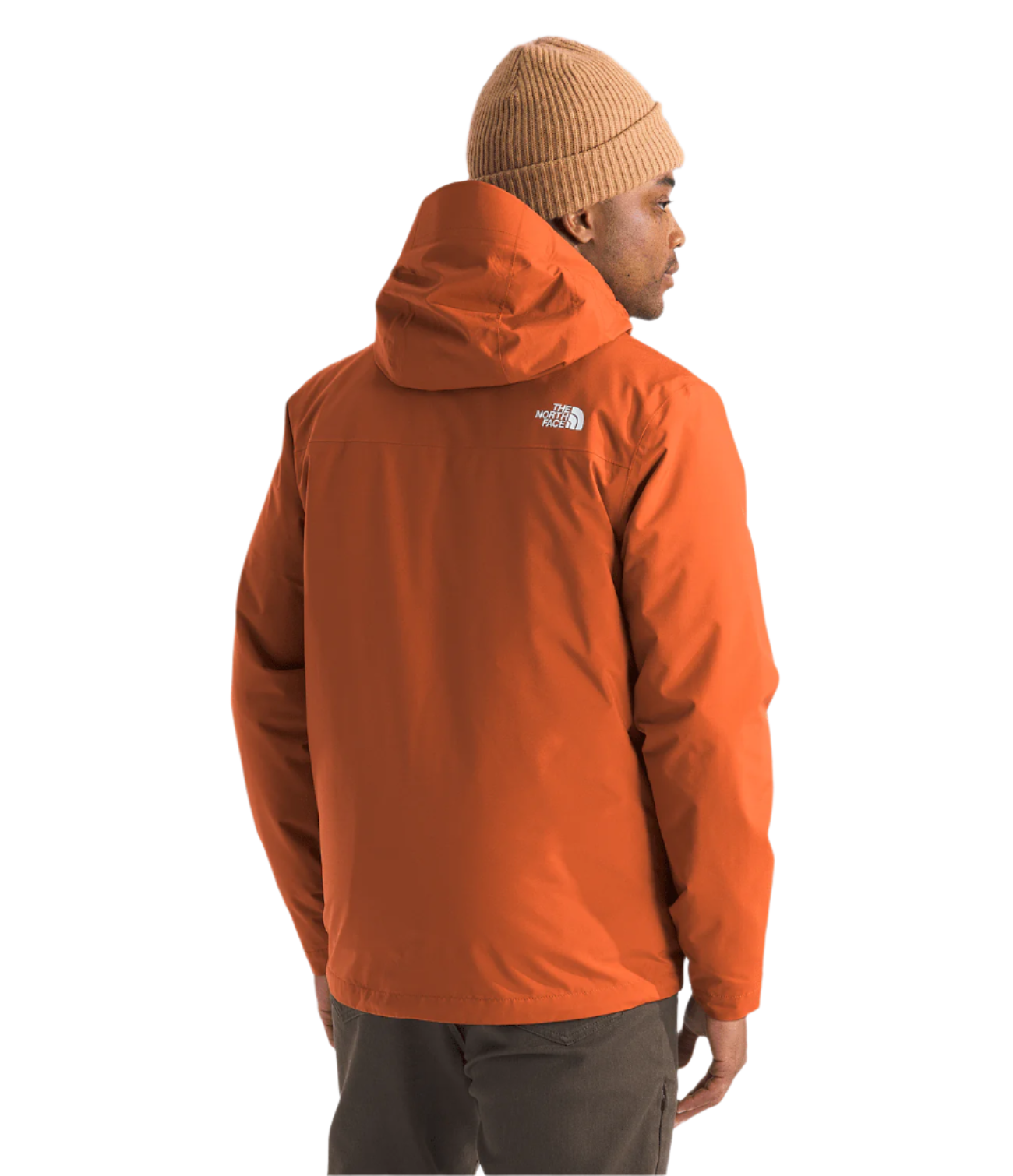 North Face Carto Triclimate Jacket - A man wearing a burnt orange jacket with a white logo on the upper left side of the back, facing away from the camera.