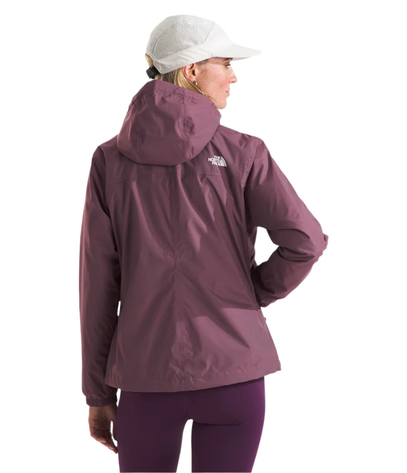 North Face Women's Antora Triclimate Jacket - A woman wearing a white cap and a purple jacket with a hood, standing in front of a light gray background.