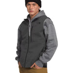 North Face Apex Bionic Vest - A dark gray vest with a zippered front and two side pockets, worn by a model over a light gray hoodie.
