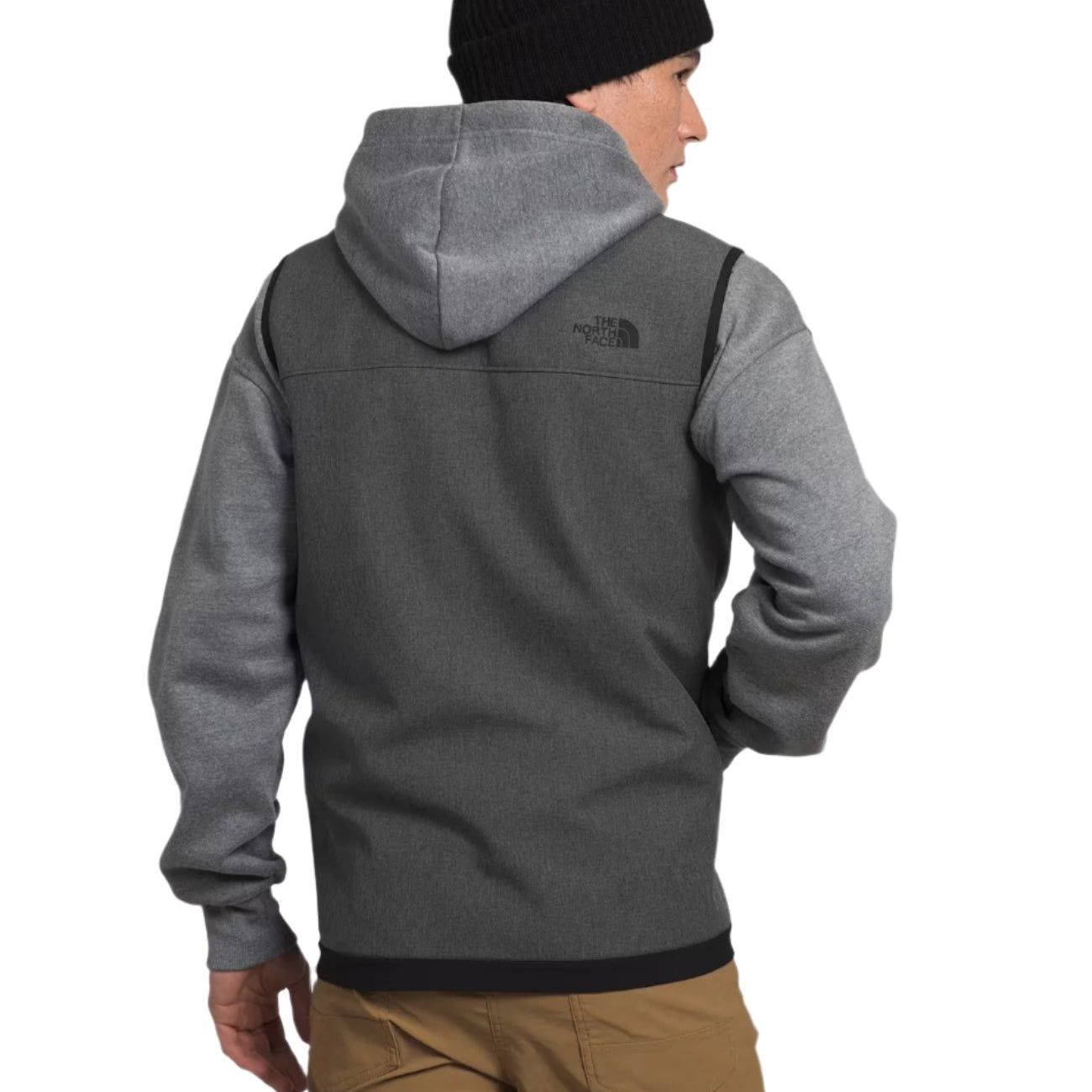 North Face Apex Bionic Vest - A man wearing a gray hooded sweatshirt with a black logo on the upper left chest area, paired with khaki pants and a black beanie.