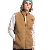 North Face Apex Bionic Vest - A man wearing a tan-colored vest with two zippered pockets on the front, standing against a white background.