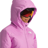 North Face Girls' Freedom Insulated Jacket - A young girl wearing a pink jacket with a white logo on the left chest, looking down at something out of frame.