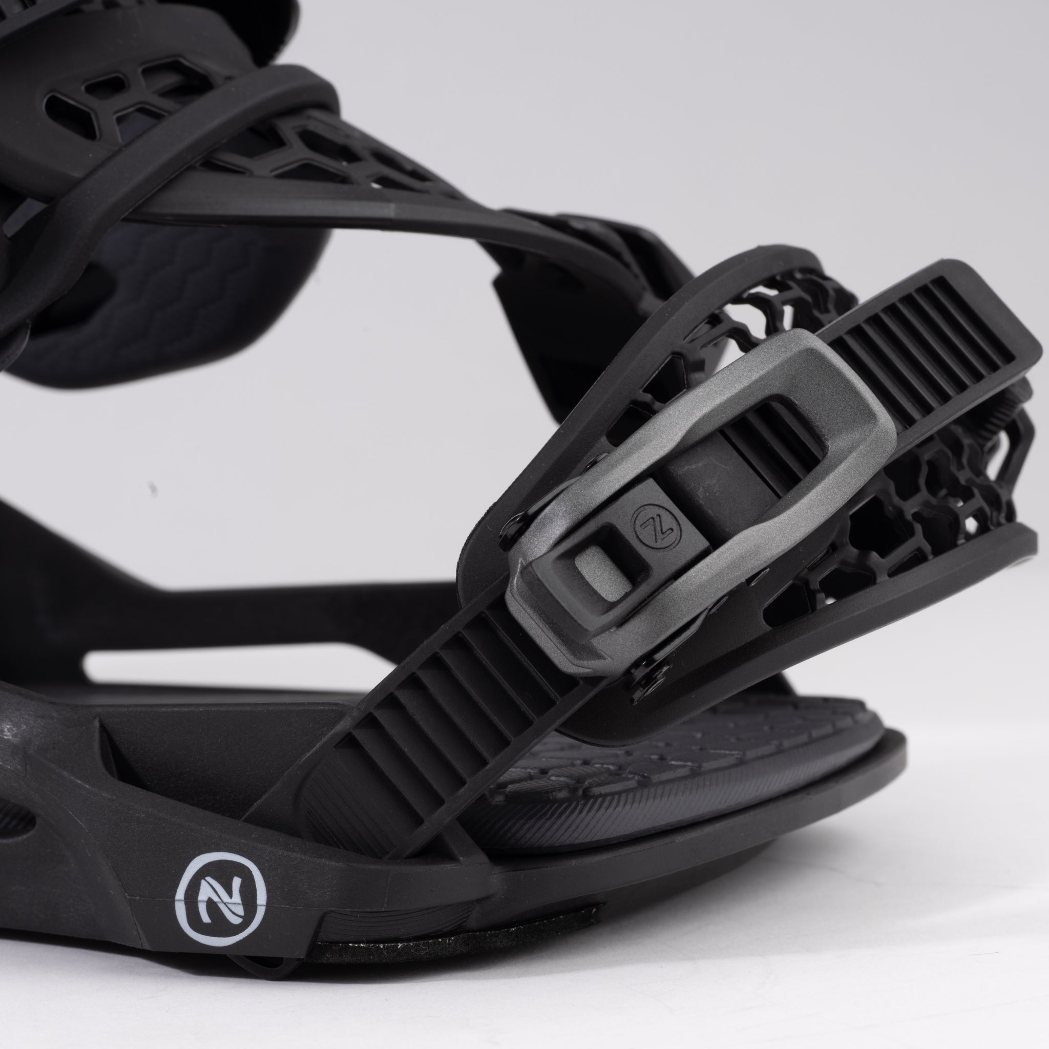 Nidecker Kaon Snowboard Binding - A black snowboard binding with a circular logo on the strap and a textured surface.