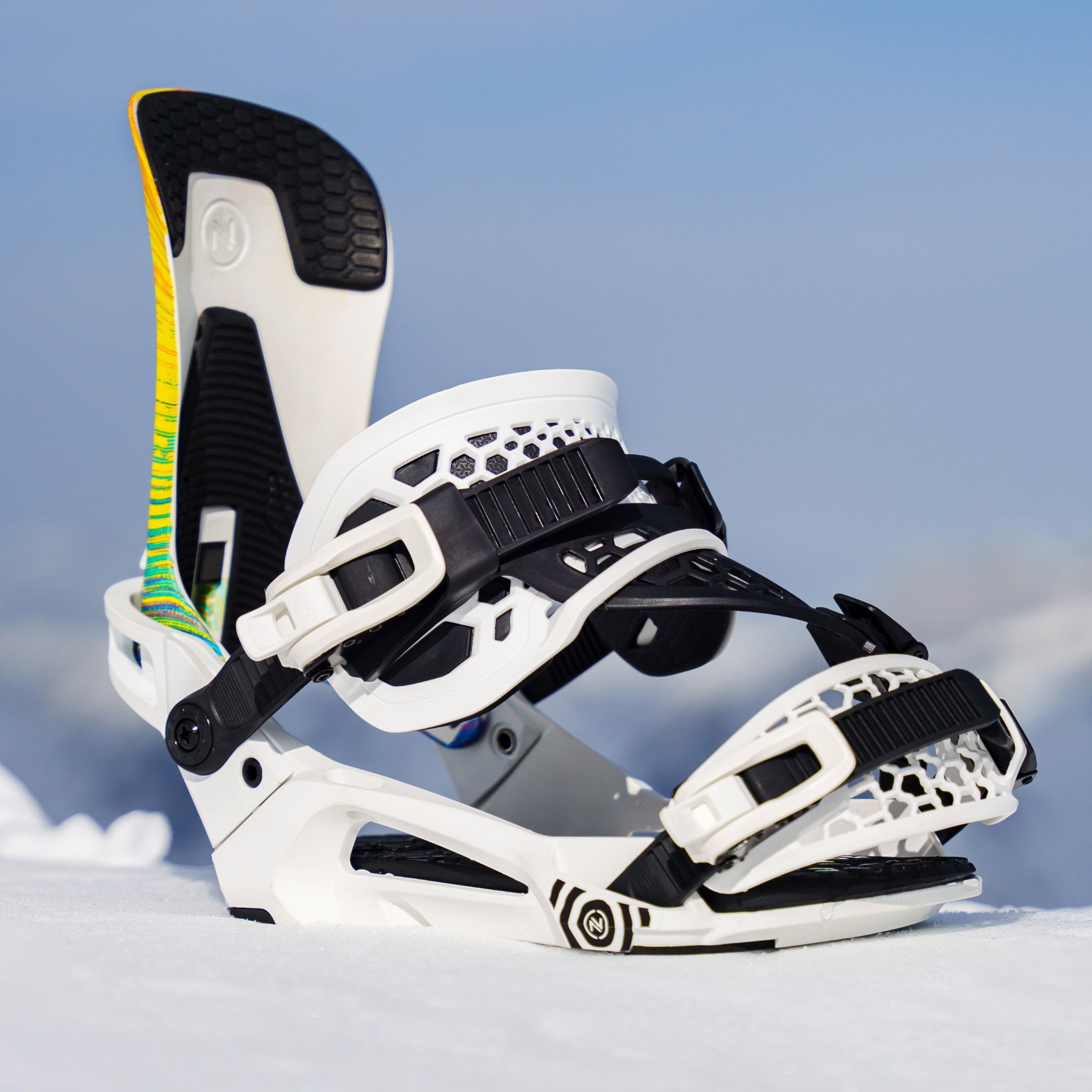 Nidecker Kaon Plus Snowboard Binding - A white snowboard binding with black buckles and a yellow, green, and blue striped strap on the left side.