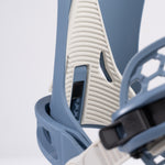 Nidecker Kaon Snowboard Binding 2025 - A snowboard binding with a white base and blue accents, featuring a textured pattern on the straps.