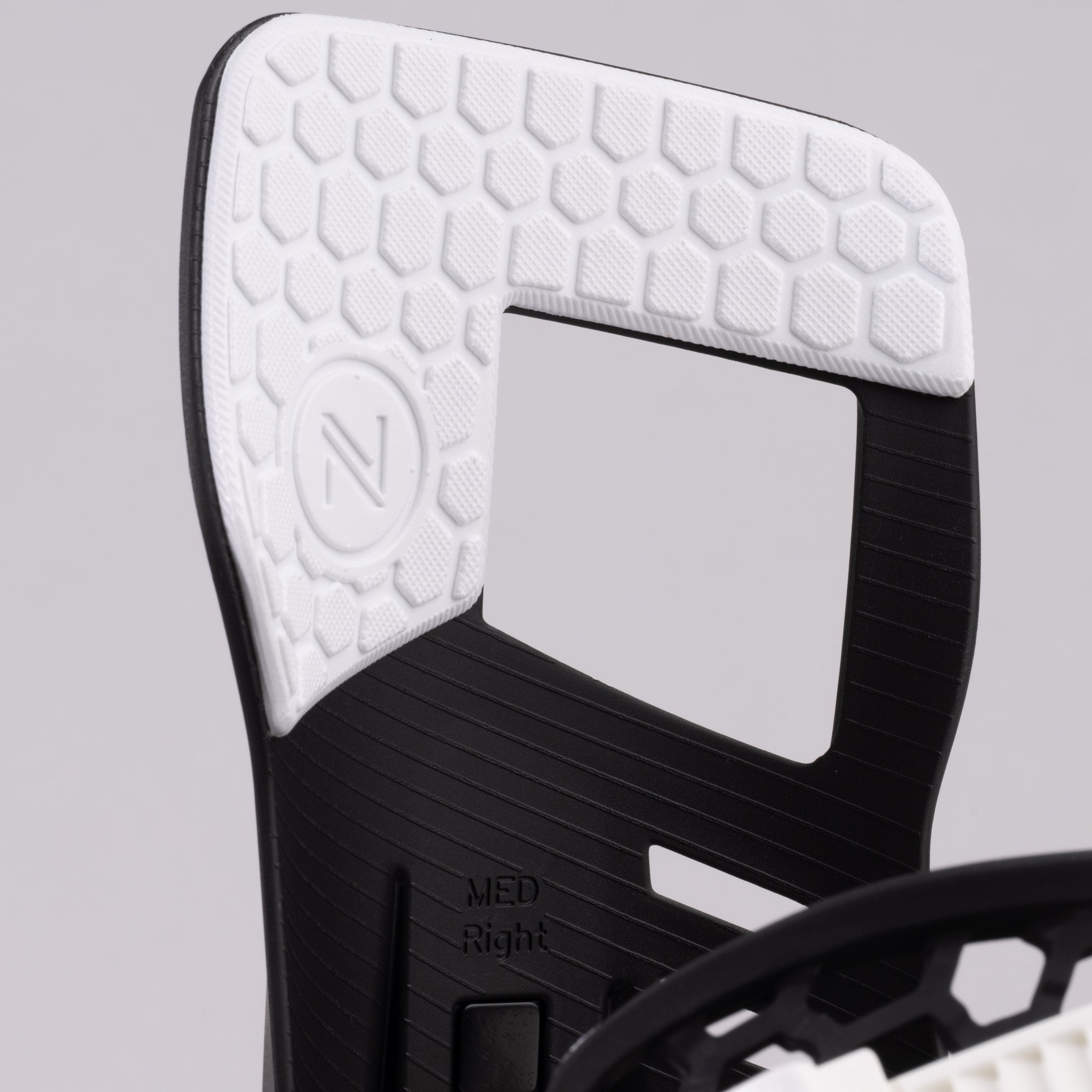 Nidecker Prime Youth Snowboard Bindings 2025 - A black and white snowboard binding with a textured top surface, featuring a circular logo on the left side.