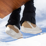 Nidecker Women's Cascade Snowboard Boot 2025 - A pair of tan and white snowboard boots with a textured sole, viewed from below.