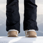 Nidecker Women's Cascade Snowboard Boot 2025 - A pair of black snowboard boots with a tan and white sole, viewed from the back.