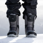 Nidecker Sierra Men's Snowboard Boots 2025 - A pair of black snowboard boots with a textured rubber sole and laces, standing on a snowy surface.