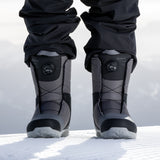 Nidecker Sierra Men's Snowboard Boots 2025 - A pair of black snowboard boots with a textured rubber sole and laces, standing on a snowy surface.