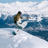 Nidecker Alpha Snowboard 2025 - A white snowboard with black and blue bindings, featuring a wolf logo on its bottom edge.
