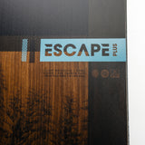 Nidecker Escape Plus Snowboard 2025 - A black snowboard with a white logo and text on top of a wooden background.