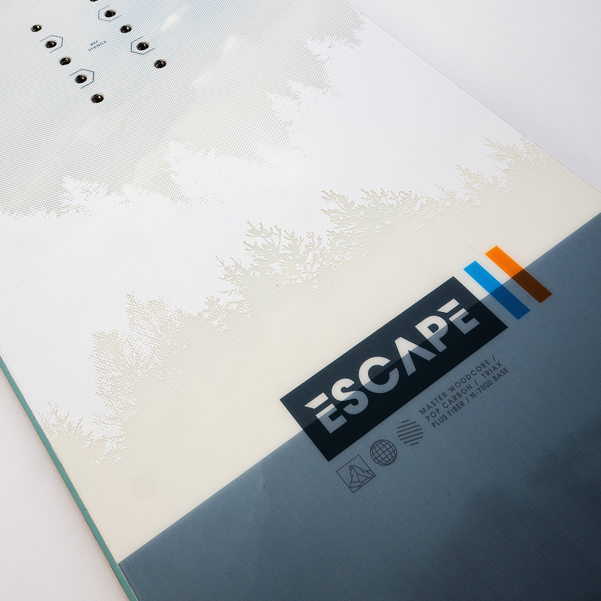 Nidecker Escape Snowboard 2025 - A white snowboard with a subtle gray pattern of trees and mountains in the background.